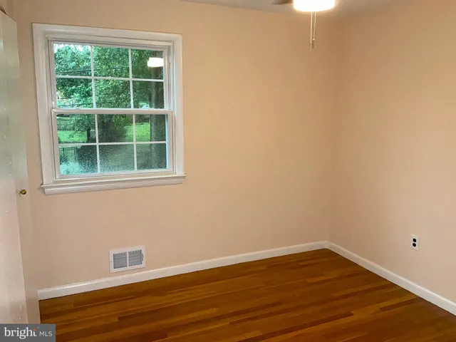 a view of a small space with wooden floor and a window