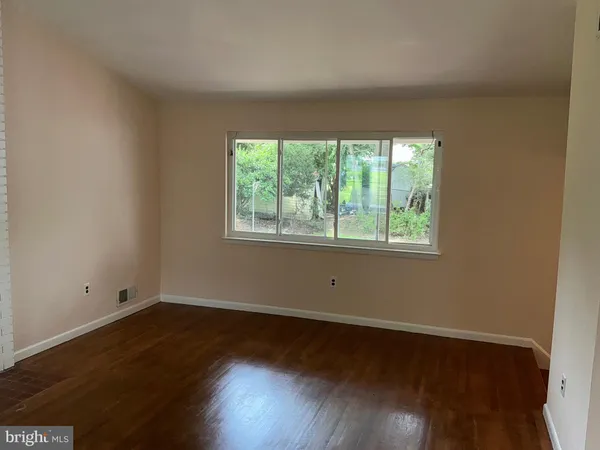 a view of a room with wooden floor and window