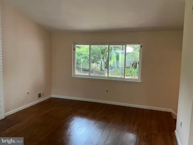a view of a room with wooden floor and window