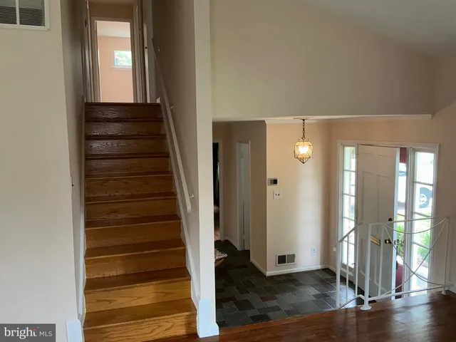 a view of a hallway with wooden floor and staircase