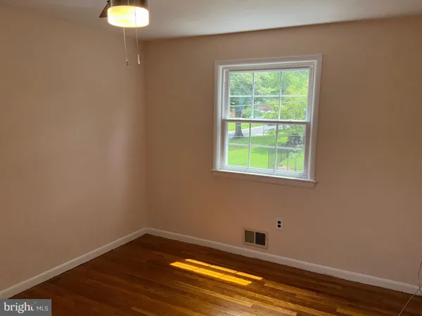 a view of a small space with wooden floor and a window
