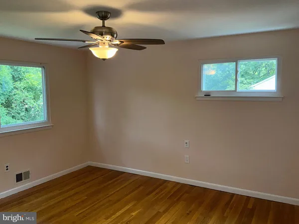 a view of a room with wooden floor and fan
