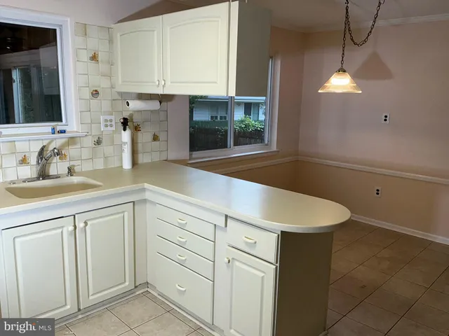 a kitchen with white cabinets and sink