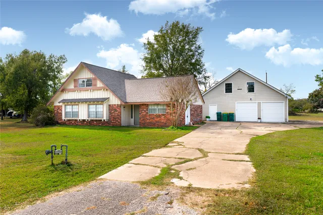 a front view of house with yard and trees in the background