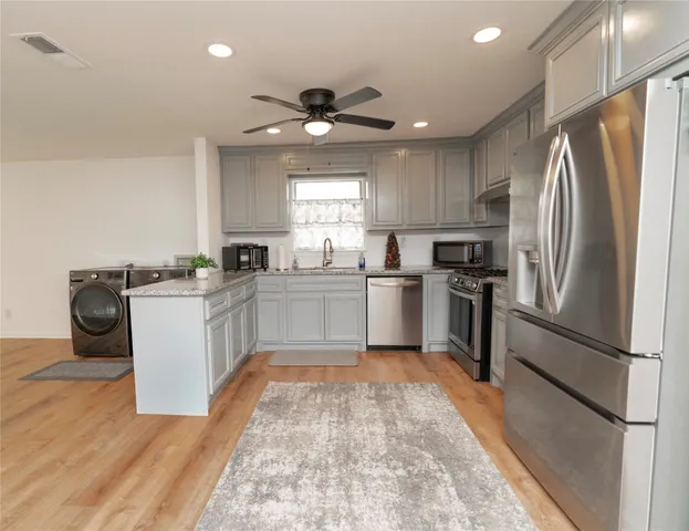 a kitchen with a refrigerator sink and cabinets