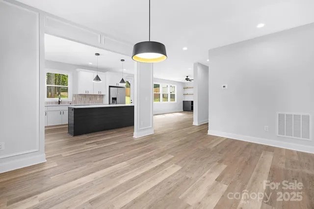 a view of a kitchen with a stove wooden cabinets and a chandelier