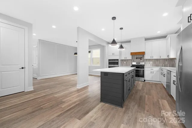 a kitchen with a refrigerator and a stove top oven