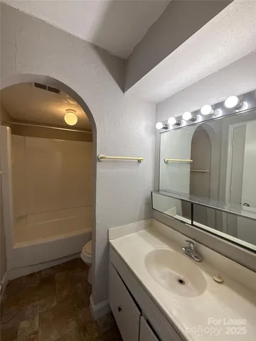 a bathroom with a toilet and a bathtub