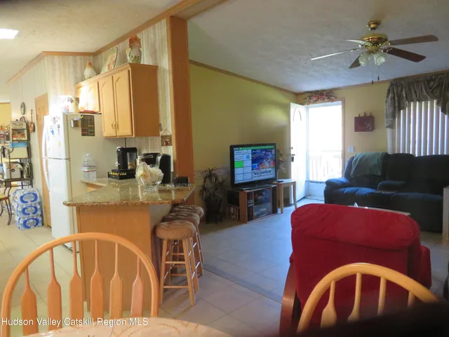 a living room with furniture two window and a flat screen tv