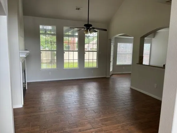 an empty room with wooden floor and windows
