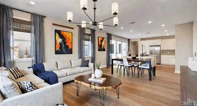 a living room with furniture a dining table and a large window