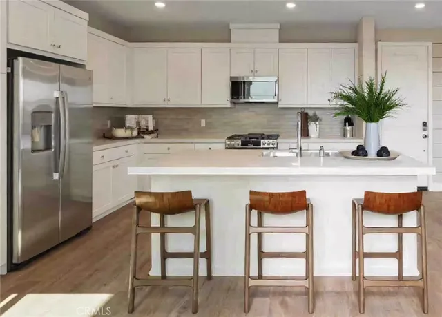 a kitchen with stainless steel appliances granite countertop a white cabinets and a stove top oven