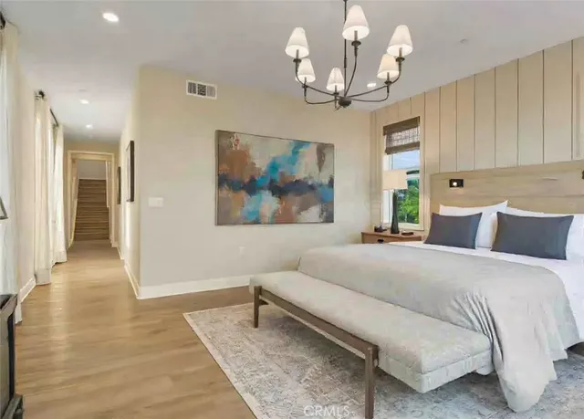 a spacious bedroom with a bed and a chandelier