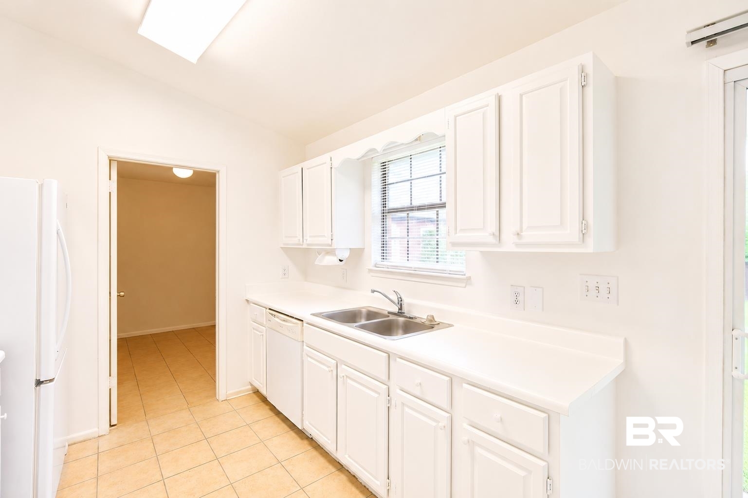 614 East Gate Circle Foley, AL 36535 - Photo 12 of 31 Kitchen featuring white cabinetry, a dual basin stainless steel sink, and white laminate countertops