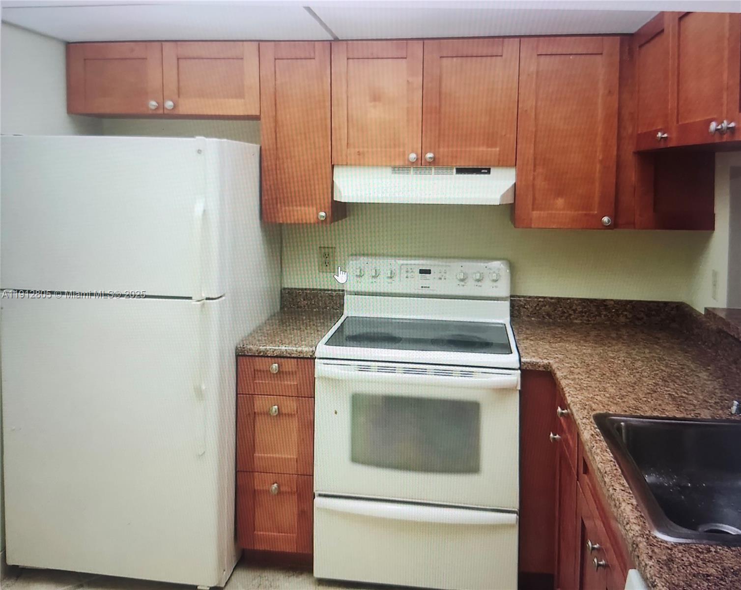 9450 Poinciana Place, Unit 205 Davie, FL 33324 - Photo 9 of 9 a kitchen with a stove and a refrigerator