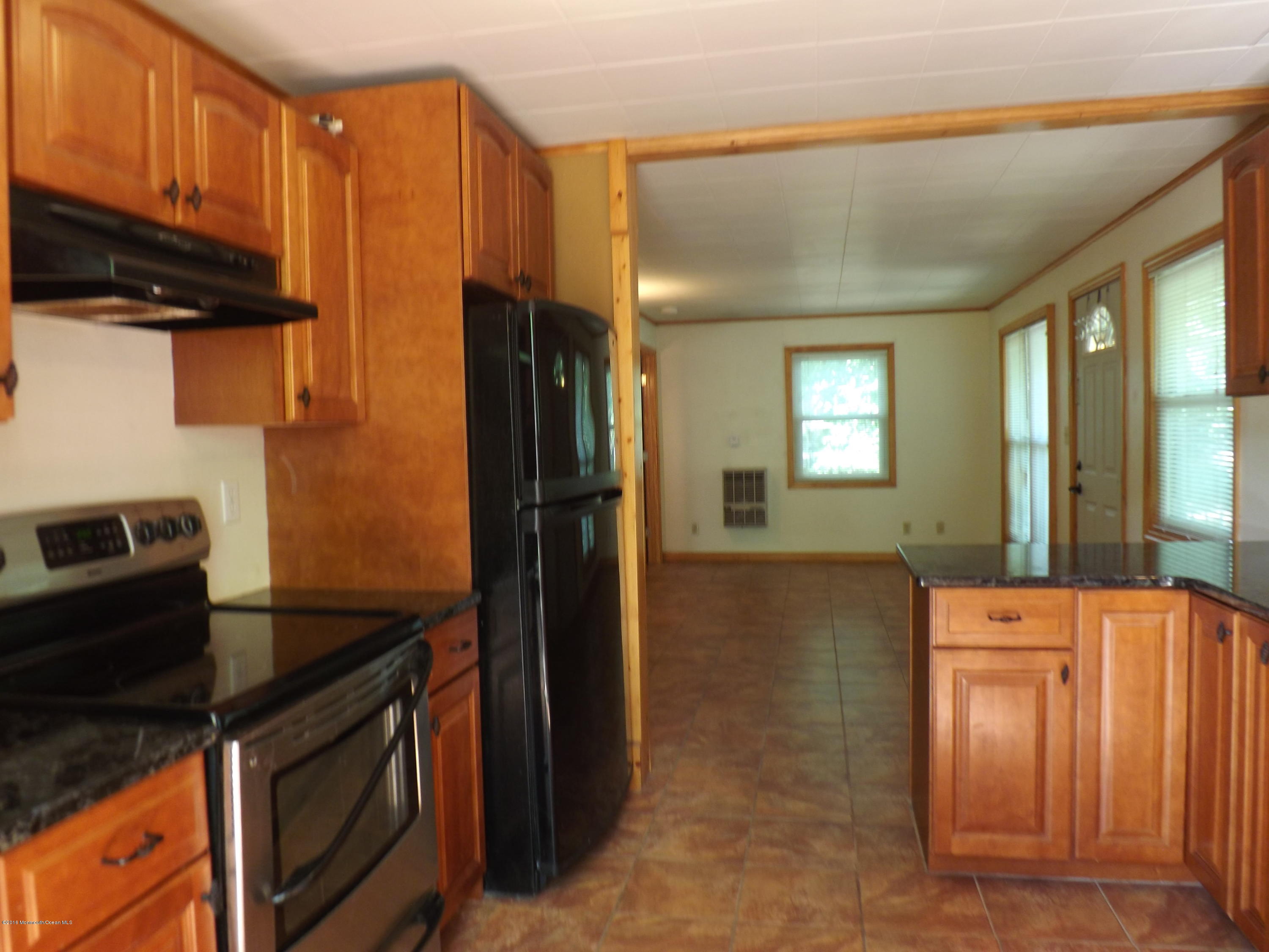73 Lemon Road Howell, NJ 07731 - Photo 6 of 17 a kitchen with stainless steel appliances granite countertop a refrigerator a stove and a sink with wooden cabinets