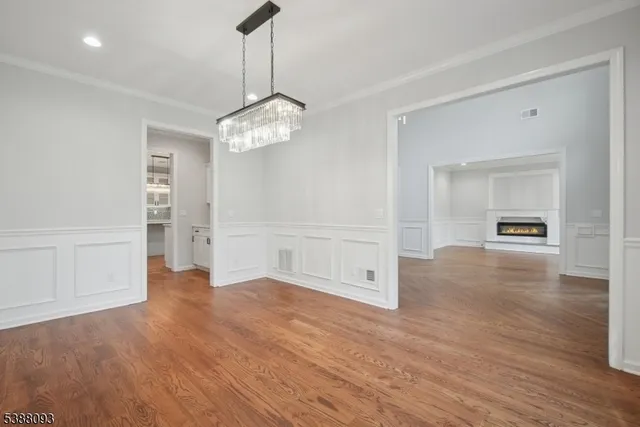 a view of a livingroom with wooden floor and a refrigerator