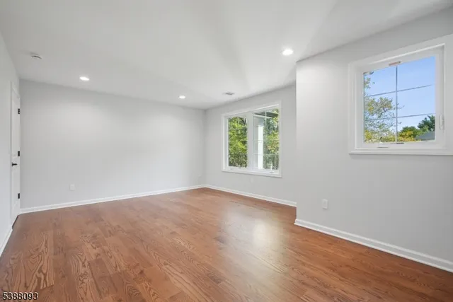 an empty room with wooden floor and window
