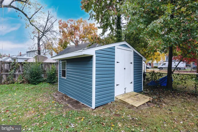 a view of backyard with a barn and a large tree