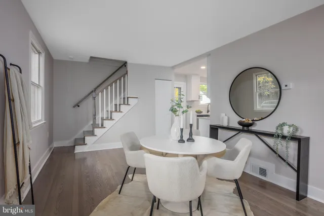 a view of a dining room with furniture a potted plant and wooden floor