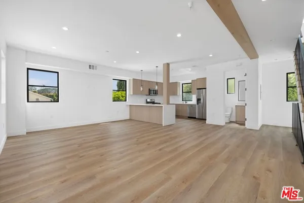 a view of a kitchen with a refrigerator cabinets and a wooden floor