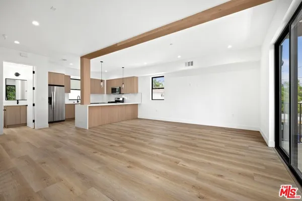 a view of a kitchen with wooden floor and a kitchen
