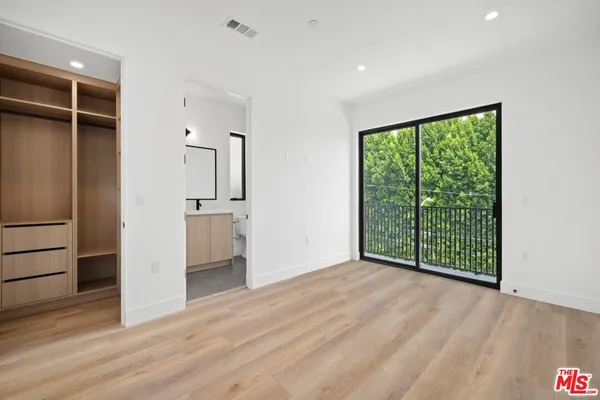 an empty room with wooden floor and a large window