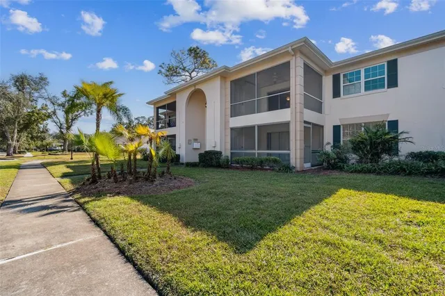a view of a house with swimming pool lawn chairs and a yard