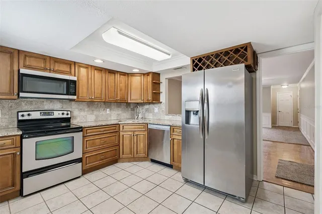 a kitchen with stainless steel appliances granite countertop a refrigerator and a sink