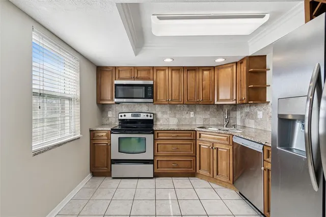 a kitchen with stainless steel appliances granite countertop a refrigerator and a sink