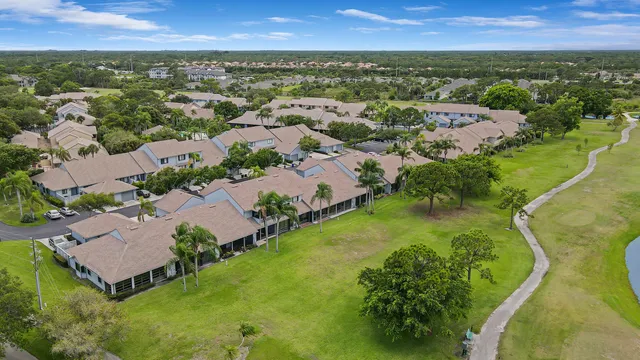 an aerial view of residential houses with outdoor space and trees