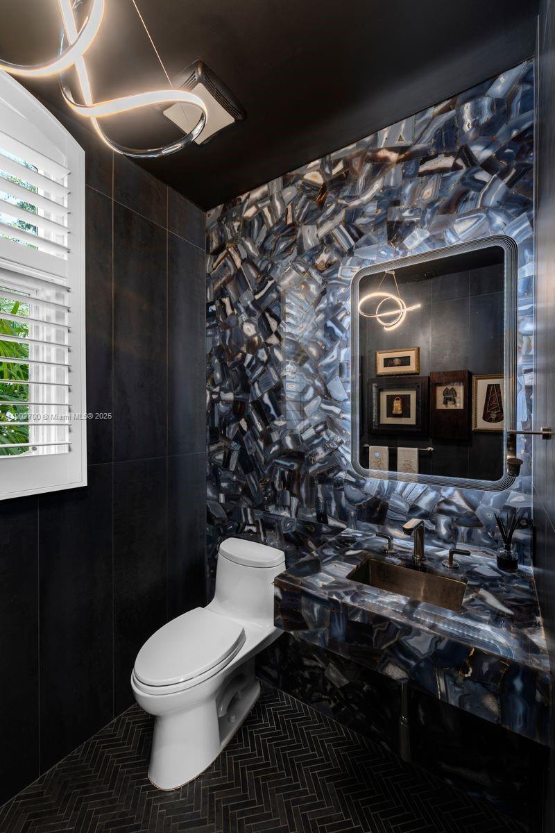 5770 Southwest 100th Street Pinecrest, FL 33156 - Photo 12 of 57 a bathroom with a toilet sink and mirror