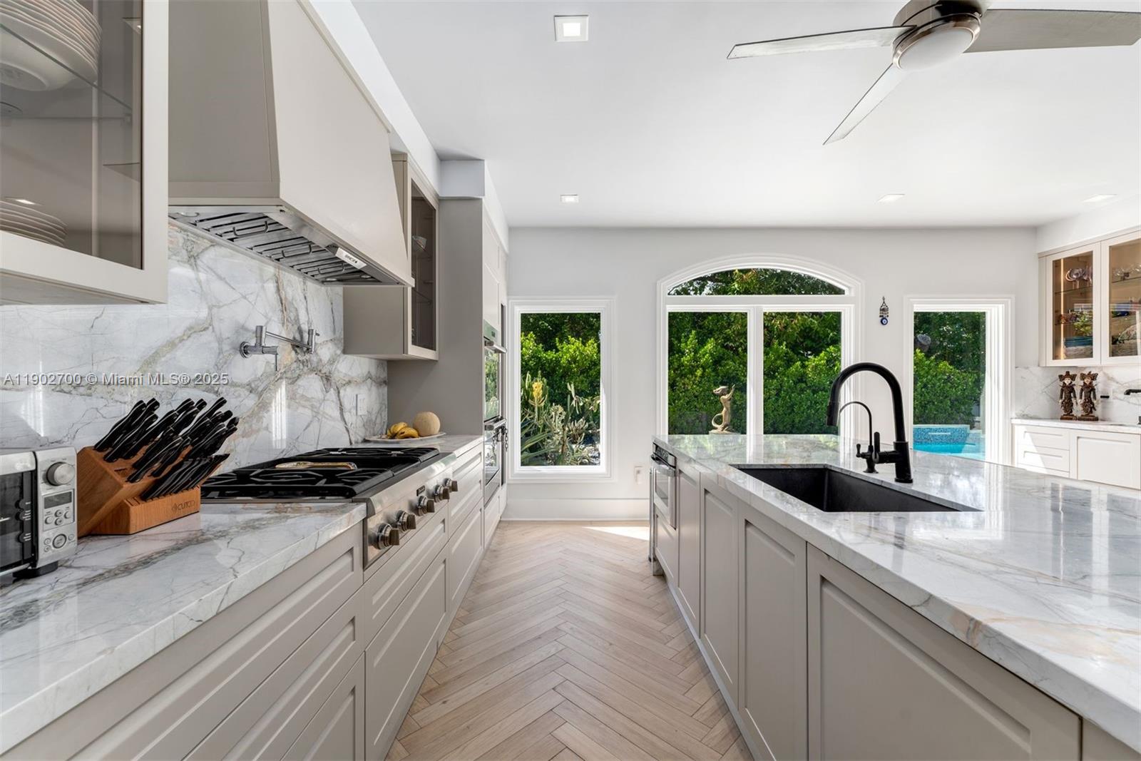 5770 Southwest 100th Street Pinecrest, FL 33156 - Photo 16 of 57 a kitchen with large windows a stove and a sink