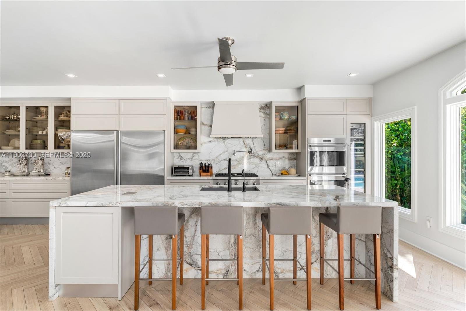 5770 Southwest 100th Street Pinecrest, FL 33156 - Photo 18 of 57 a kitchen with kitchen island granite countertop a table and chairs in it