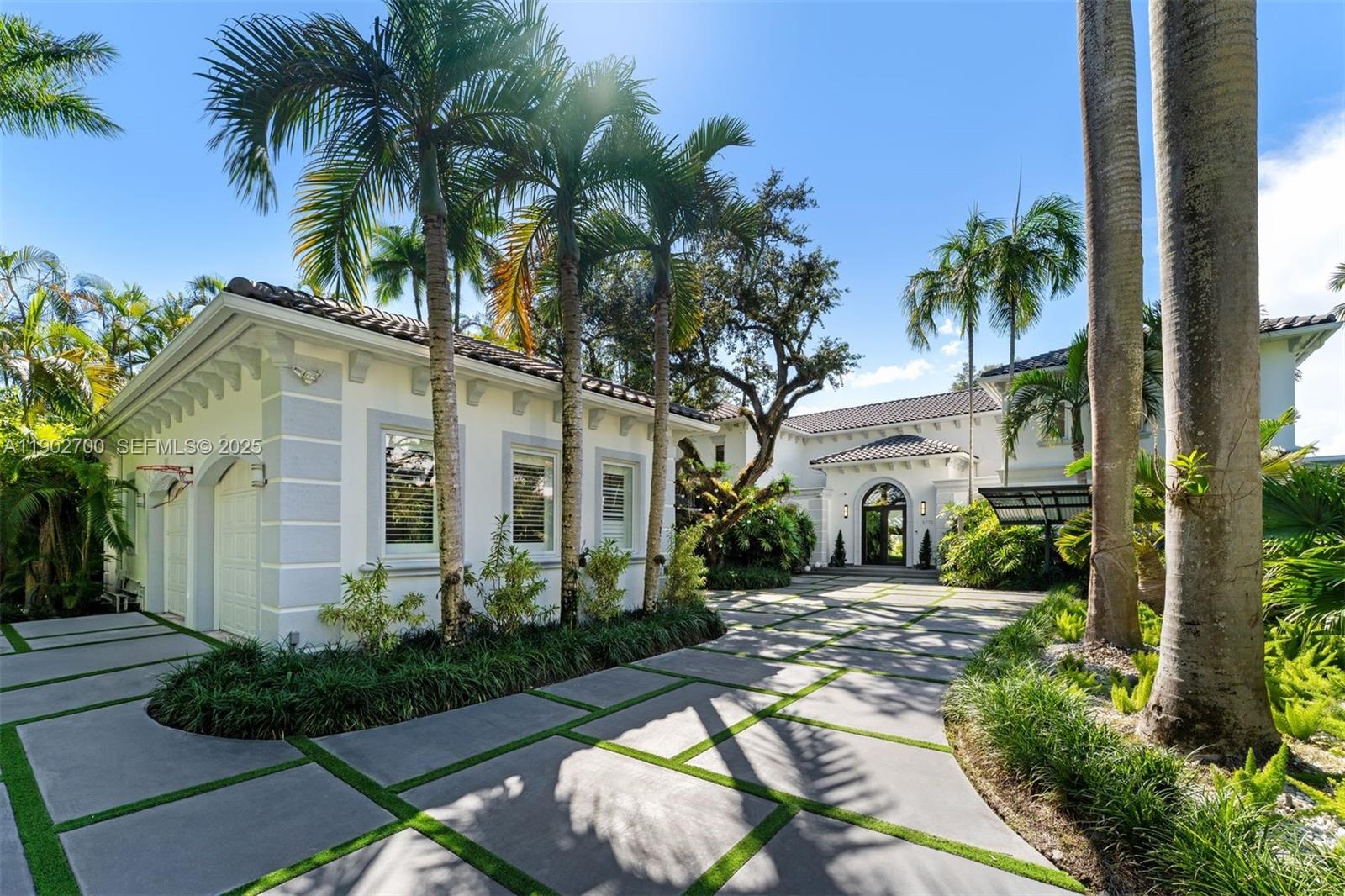 5770 Southwest 100th Street Pinecrest, FL 33156 - Photo 2 of 57 a front view of a house with a garden