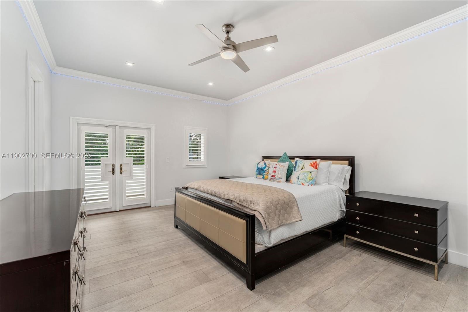 5770 Southwest 100th Street Pinecrest, FL 33156 - Photo 32 of 57 a bedroom with a bed a window and a chandelier