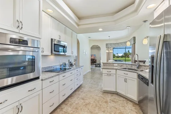 a kitchen with stainless steel appliances granite countertop a stove a sink and a microwave