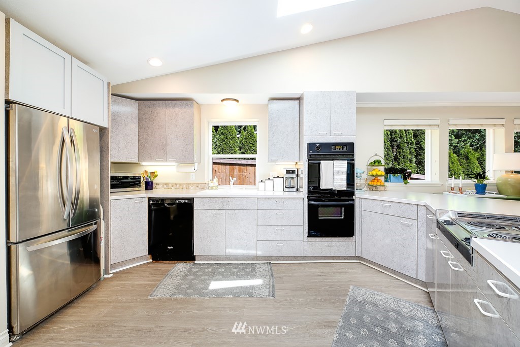 19637 Southeast 149th Street Renton, WA 98059 - Photo 2 of 29 a kitchen with granite countertop a refrigerator oven a sink a stove and stainless steel appliances
