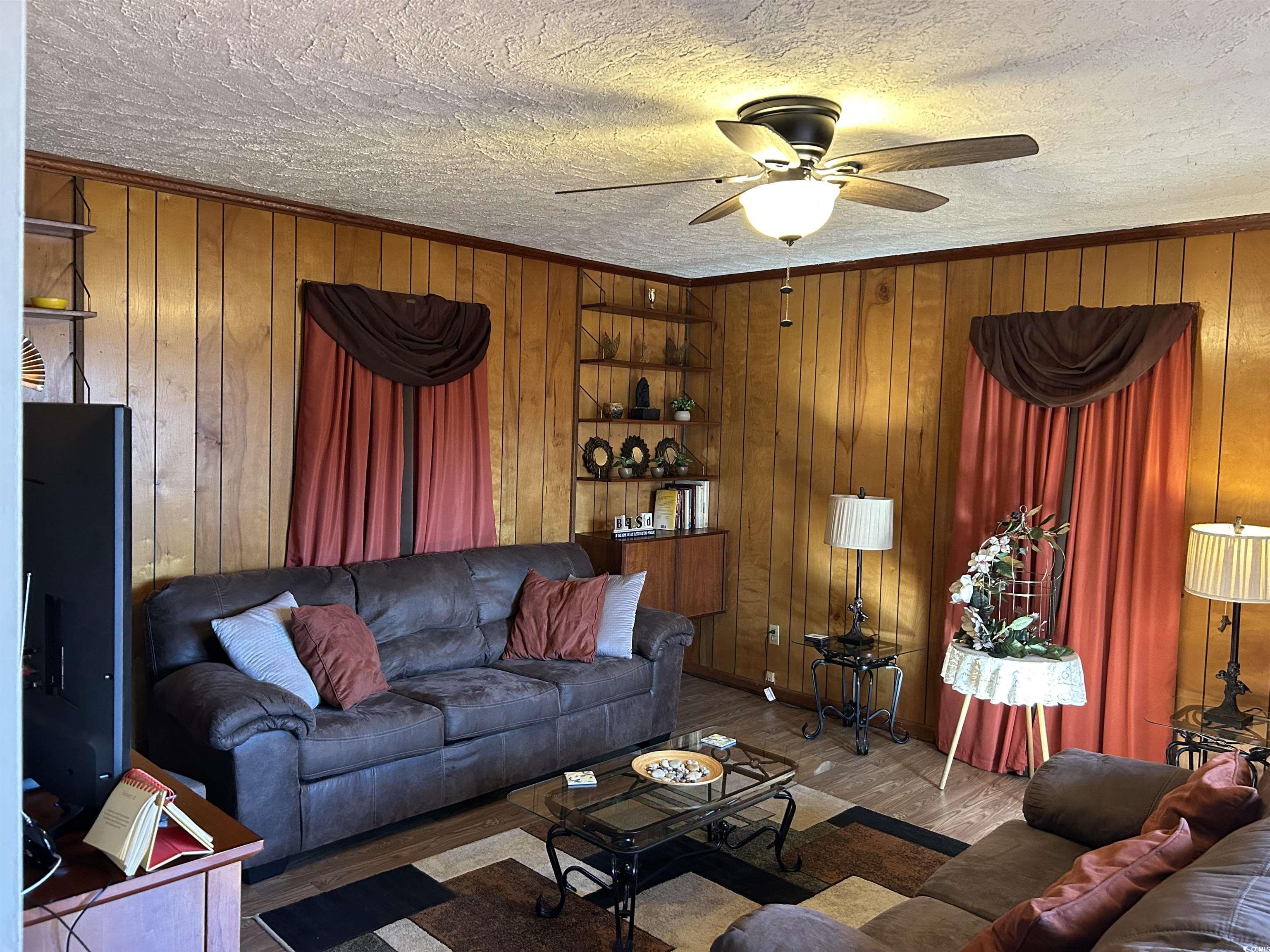 1411 East Harrison Street Dillon, SC 29536 - Photo 16 of 40 Den with wood finished floors, ceiling fan, wood walls, a textured ceiling, and ornamental molding