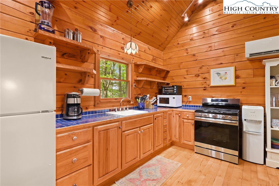151 Cascade Drive Purlear, NC 28665 - Photo 11 of 46 a kitchen with stainless steel appliances granite countertop a stove a sink and a refrigerator