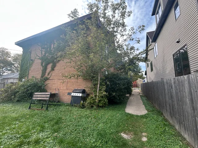 a view of a house with backyard and sitting area