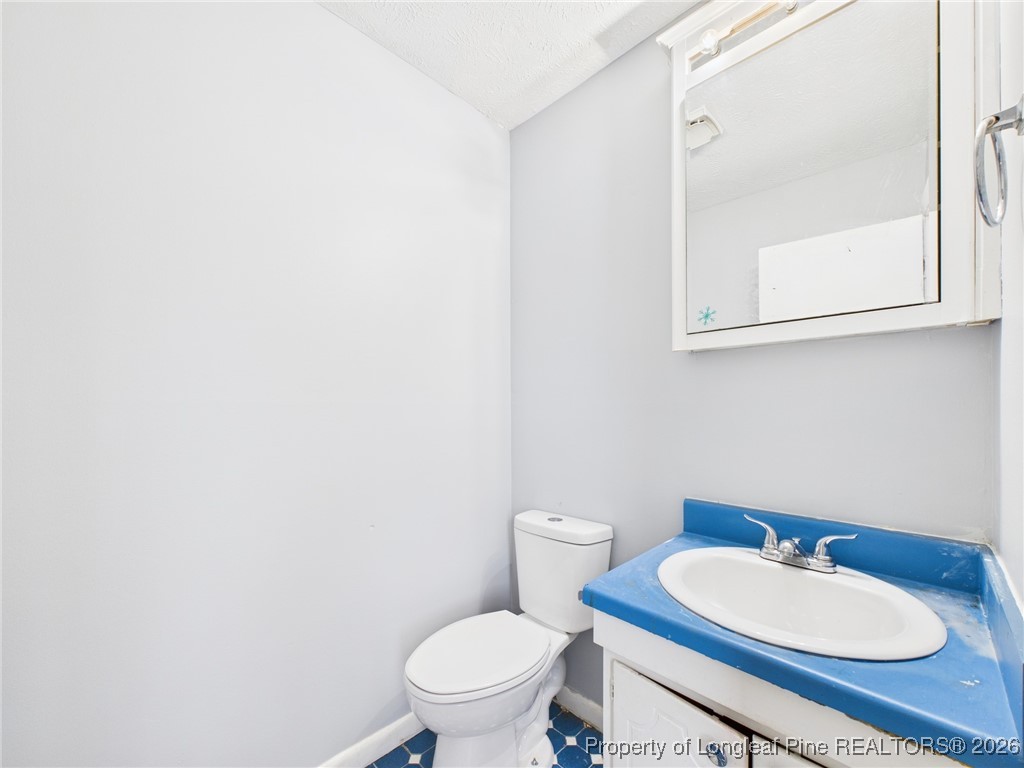 1540 Mack Street Spring Lake, NC 28390 - Photo 31 of 31 a bathroom with a toilet a sink and mirror
