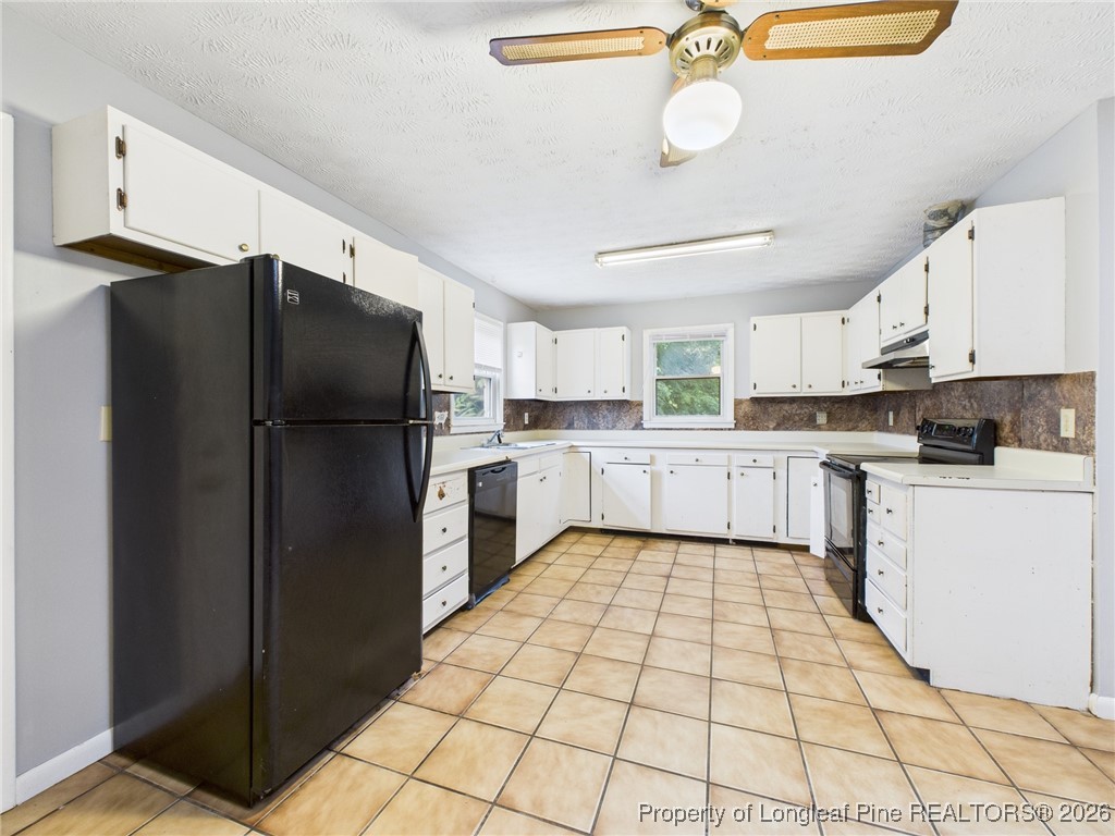 1540 Mack Street Spring Lake, NC 28390 - Photo 10 of 31 a kitchen with a refrigerator a stove top oven and white cabinets