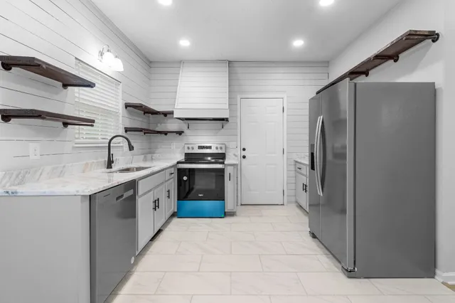 a kitchen with stainless steel appliances granite countertop a refrigerator and a sink
