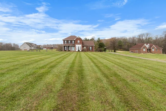 a view of a big yard with a house in the background
