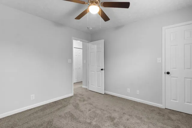 an empty room with chandelier fan