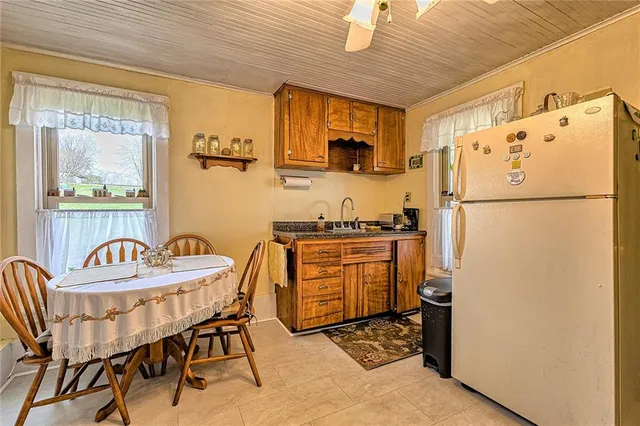 a kitchen with stainless steel appliances granite countertop a refrigerator a stove a sink dishwasher a dining table and chairs with wooden floor