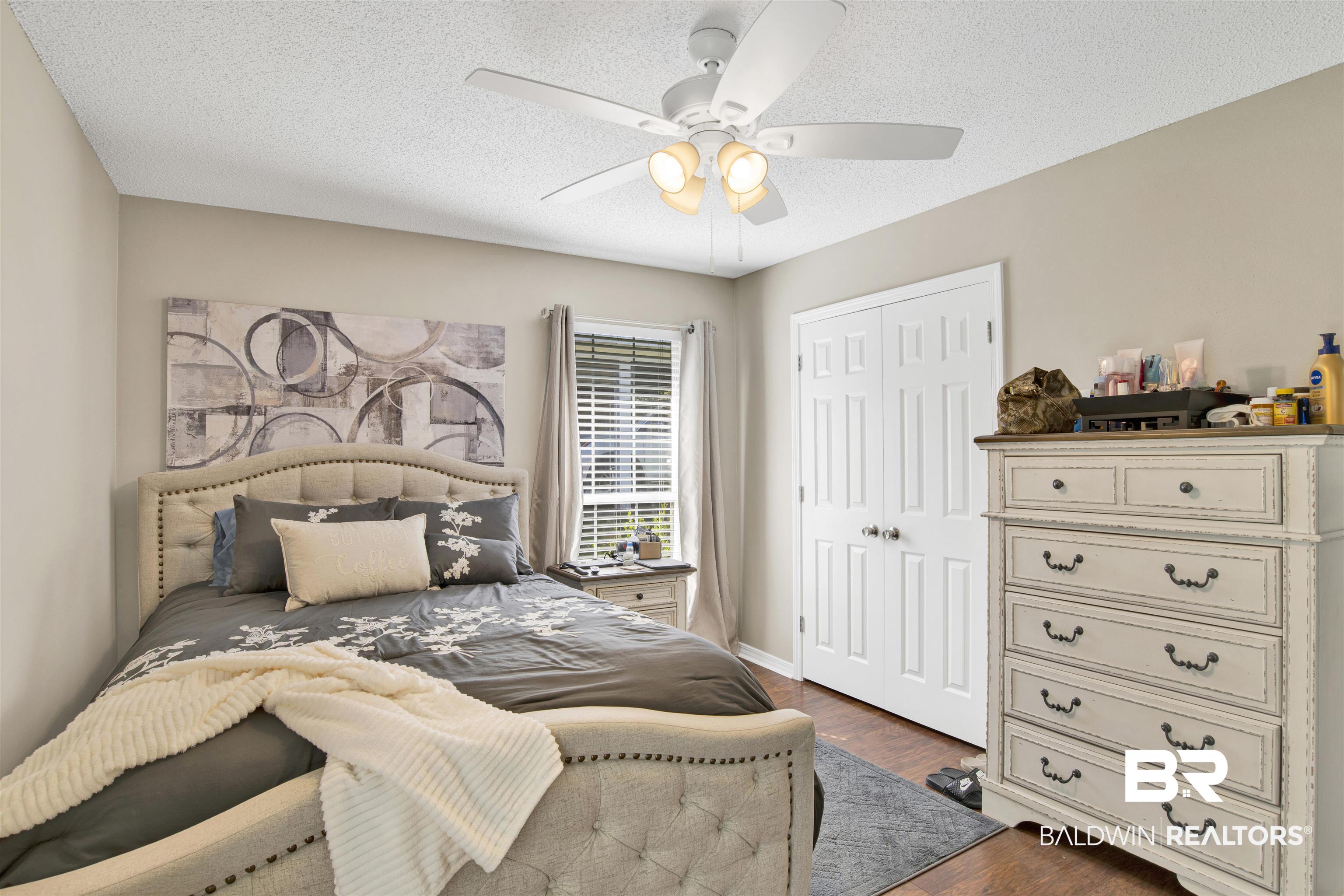 6281 Woodside Drive Theodore, AL 36582 - Photo 11 of 17 Bedroom with dark wood-type flooring, a closet, a textured ceiling, and a ceiling fan
