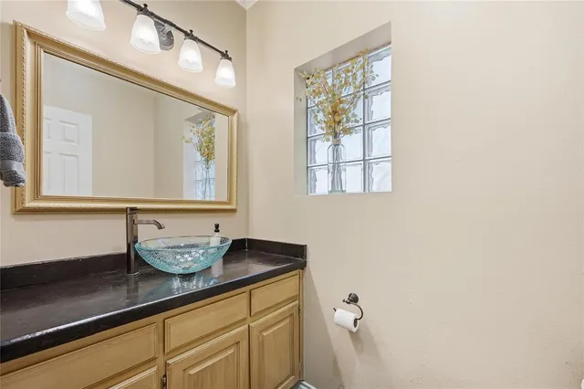 a bathroom with a granite countertop sink and a mirror