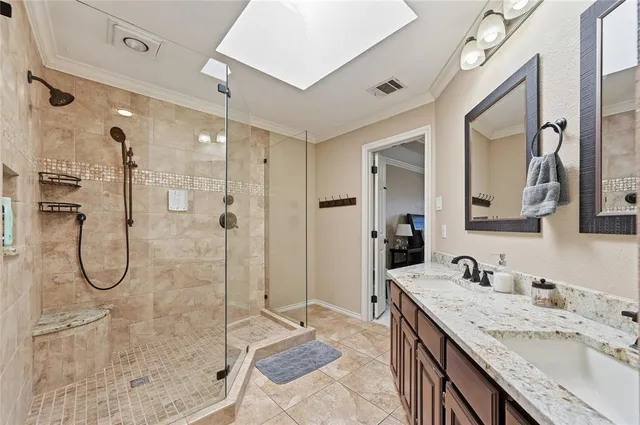 a bathroom with a granite countertop sink a mirror and a shower